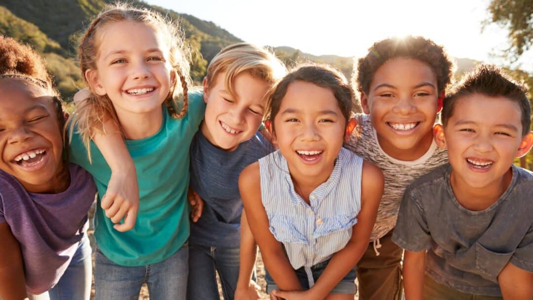 Culturally Diverse Children Smiling in a group with arms around each other