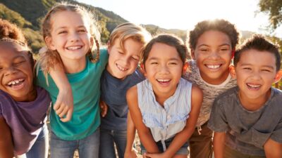 Culturally Diverse Children Smiling in a group with arms around each other
